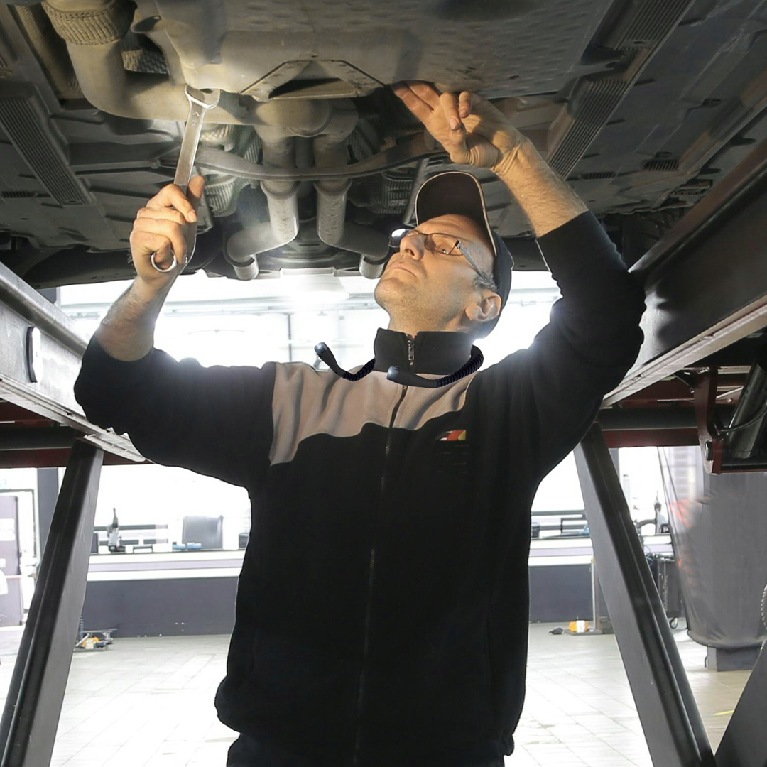 mechanic working on car with neck light