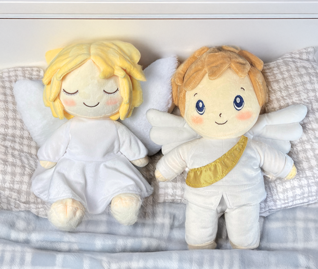 Two angel plush toys on a checkered fabric background