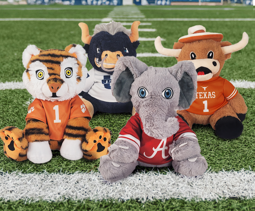 Four plush toys representing different sports teams on a football field